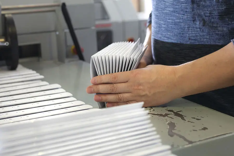 A person stacking prints